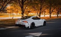 Car parked on the side of the road with tress in the background